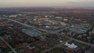 AX0163_0010 - 4K aerial stock footage of approaching a shopping mall by suburban neighborhood at sunset in Burr Ridge, Illinois