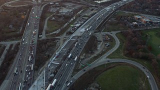 AX0163_0012 - 4K aerial stock footage of heavy traffic on a freeway interchange at sunset in Burr Ridge, Illinois