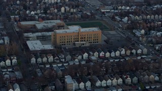 AX0163_0020 - 4K aerial stock footage of approaching elementary schools at sunset in West Side Chicago, Illinois