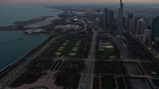 AX0163_0043 - 4K aerial stock footage of Grant Park and the Field Museum from Lake Michigan at twilight, Downtown Chicago, Illinois