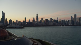 AX0163_0047 - 4K aerial stock footage flyby Adler Planetarium, reveal and approach city skyline at twilight, Downtown Chicago, Illinois