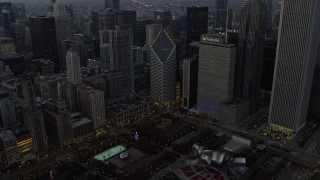 AX0163_0050 - 4K aerial stock footage approach skyscraper, tilt to Grant Park monuments at twilight, Downtown Chicago, Illinois