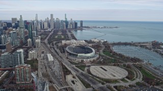 AX0165_0061 - 4K aerial stock footage of flying by Soldier Field football stadium, reveal Downtown Chicago skyline, Illinois