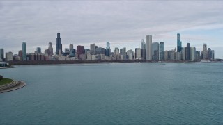 AX0165_0063 - 4K aerial stock footage of flying past Adler Planetarium to approach Downtown Chicago skyline, Illinois