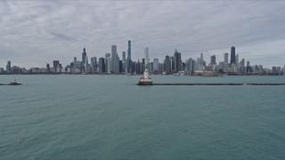 AX0165_0071 - 4K aerial stock footage fly over lighthouse to approach the Downtown Chicago skyline, Illinois