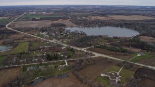 AX0166_0045 - 4K aerial stock footage of rural homes by George Lake in Bristol, Wisconsin