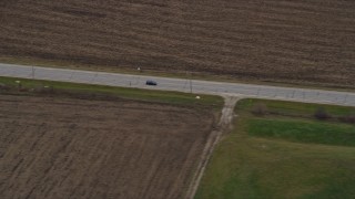 AX0166_0047 - 4K aerial stock footage of a car traveling on a country road in Bristol, Wisconsin