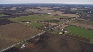 AX0166_0052 - 4K aerial stock footage of passing farms and fields beside a country road in Union Grove, Wisconsin