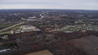AX0166_0061 - 4K aerial stock footage of flying over fields toward a rural neighborhood, Franklin, Wisconsin
