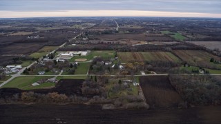 AX0167_0039 - 4K aerial stock footage of flying over farms and fields around an elementary school in Franksville, Wisconsin