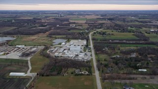 AX0167_0041 - 4K aerial stock footage of flying over a manufacturing plant, fields and farms in Franksville, Wisconsin