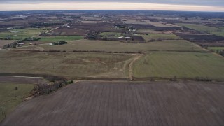 AX0167_0045 - 4K aerial stock footage of flying over fields toward farms in Union Grove, Wisconsin