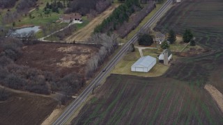 AX0167_0047 - 4K aerial stock footage of a car traveling a county road in Union Grove, Wisconsin
