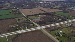AX0167_0048 - 4K aerial stock footage of flying over fields and farms toward 75th Street in Bristol, Wisconsin