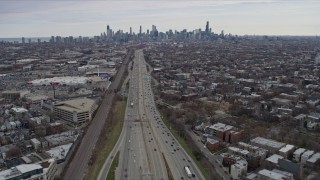 AX0167_0080 - 4K aerial stock footage of light freeway traffic, tilt to reveal the Downtown Chicago skyline, Illinois