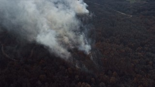 AX0168_0023 - 4K aerial stock footage of plumes of smoke rising from a fire in the forest, Willow Springs, Illinois