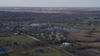 AX0168_0025 - 4K aerial stock footage of upscale homes near small lakes in a quiet neighborhood in Lemont, Illinois