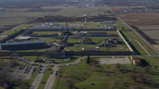 AX0168_0042 - 4K aerial stock footage of circling around and flying away from Stateville Correctional Center in Crest Hill, Illinois