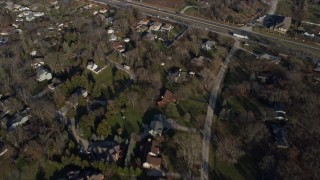 AX0169_0008 - 4K aerial stock footage of flying over an upscale suburban neighborhood and park with a lake, Willowbrook, Illinois