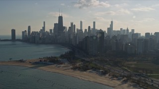 AX0169_0030 - 4K aerial stock footage tilt from Lake Michigan to reveal lakefront skyscrapers and city buildings, Downtown Chicago, Illinois