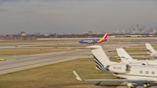 AX0169_0108 - 4K aerial stock footage of a Southwest jet taking off from Chicago Midway International Airport at sunset, Illinois