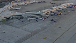 AX0170_0002 - 4K aerial stock footage of flying away from Southwest jets at Chicago Midway International Airport at sunset, Illinois