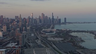 AX0170_0011 - 4K aerial stock footage wide view of the Downtown Chicago skyline, reveal Soldier Field at sunset, Illinois