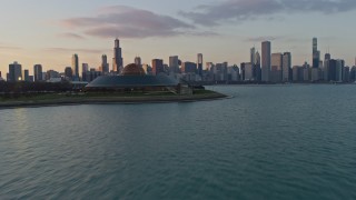 AX0170_0013 - 4K aerial stock footage fly past Adler Planetarium toward the Downtown Chicago skyline and Grant Park at sunset, Illinois