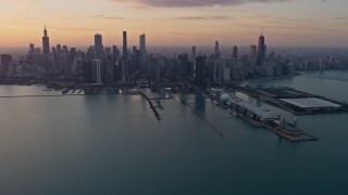 AX0170_0017 - 4K aerial stock footage slowly flyby Navy Pier to approach the Downtown Chicago skyline at sunset, Illinois