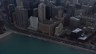 AX0170_0029 - 4K aerial stock footage a reverse view of skyscrapers and Lake Shore Drive at sunset in Downtown Chicago, Illinois