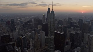 AX0170_0032 - 4K aerial stock footage focus on Willis Tower and fly past skyscrapers, reveal distant sunset, Downtown Chicago, Illinois