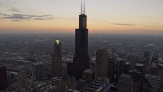 AX0170_0033 - 4K aerial stock footage fly over Willis Tower and reveal distant sunset, Downtown Chicago, Illinois