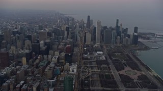 AX0170_0040 - 4K aerial stock footage of following Michigan Avenue by Grant Park toward skyscrapers at sunset, Downtown Chicago, Illinois
