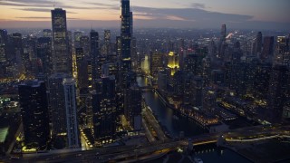 AX0170_0058 - 4K stock footage aerial video approach waterfront skyscrapers and Chicago River at twilight, tilt to Wrigley Building, Downtown Chicago, Illinois
