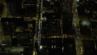 AX0170_0075 - 4K stock footage aerial video of an L Train with holiday lights traveling at night, Downtown Chicago, Illinois
