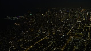 AX0170_0083 - 4K aerial stock footage a view of downtown skyscrapers, some with holiday lights at night, Downtown Chicago, Illinois