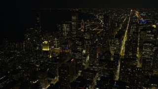 AX0170_0084 - 4K stock footage aerial video fly over downtown skyscrapers, some with holiday lights, toward Grant Park at night, Downtown Chicago, Illinois