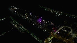 AX0170_0094 - 4K aerial stock footage of tilting to a bird's eye view of the Ferris wheel on Navy Pier at night, Chicago, Illinois