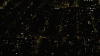 AX0170_0103 - 4K aerial stock footage of flying past urban neighborhoods on the West Side at night, Chicago, Illinois