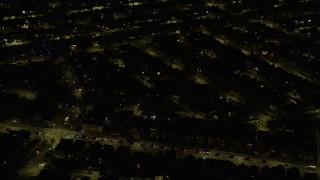 AX0170_0107 - 4K aerial stock footage of passing urban neighborhoods on the Northwest Side at night, Chicago, Illinois