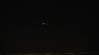 AX0170_0110 - 4K aerial stock footage of tracking a commercial jet over the Northwest Side at night, Chicago, Illinois