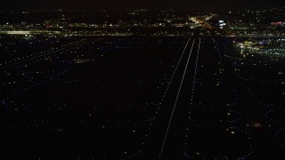 AX0170_0114 - 4K aerial stock footage a reverse view of the runways at O'Hare International Airport at night, Chicago, Illinois