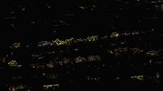AX0170_0117 - 4K aerial stock footage of suburban homes decorated for the holidays at night in Itasca, Illinois