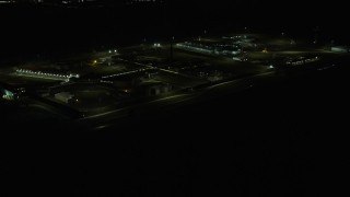 AX0170_0130 - 4K aerial stock footage of passing Stateville Correctional Center prison at night, Crest Hill, Illinois