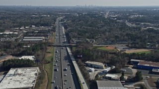AX0171_0001 - 6.7K aerial stock footage tilt from Interstate 75 traffic to reveal the Atlanta skyline, Marietta, Georgia