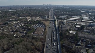 AX0171_0003 - 6.7K aerial stock footage tilt from heavy I-75 traffic to a wide view of the distant Atlanta skyline, Marietta, Georgia