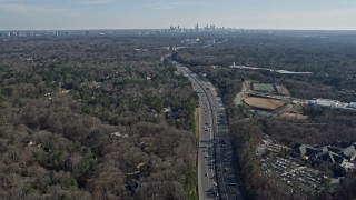 AX0171_0017 - 6.7K aerial stock footage of the distant Atlanta skyline seen from Interstate 75 and suburbs, Georgia