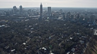 AX0171_0100 - 6.7K stock footage aerial video tilt from high school and football field to reveal Downtown and Midtown Atlanta, Georgia