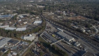 AX0171_0129 - 6.7K aerial stock footage fly over apartment buildings by train yard to reveal warehouse buildings in Decatur, Georgia