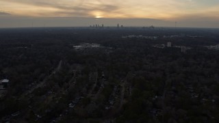 AX0171_0140 - 6.7K aerial stock footage tilt from homes in Decatur at sunset, reveal Atlanta skyline, Georgia